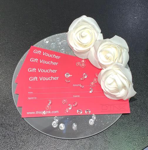 PINK gift vouchers fanned out on a silver disc and decorated with flowers and sparkly stones